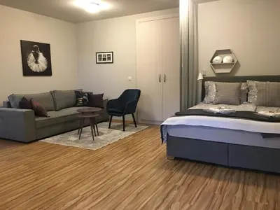 a bedroom with a bed and a couch at Apartment Nobl plac in Celje