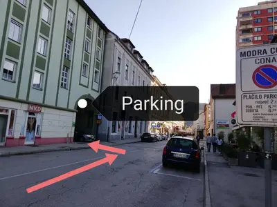 a street sign with a car parked on the street at Apartment Nobl plac in Celje