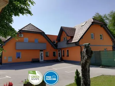a large orange building with a sign in front of it at Apartments Alexandra in Celje