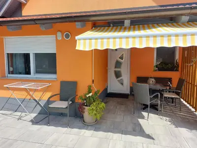 a patio with a table and chairs on a house at Apartments Alexandra in Celje