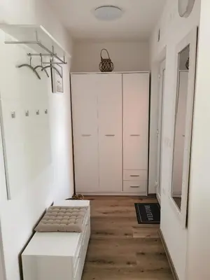 a room with a white closet and a bench at Apartments Alexandra in Celje