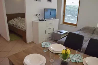 a living room with a dining table and a bedroom at COMFY and BRIGHT Apartment in Kranj