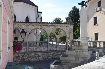 a stone fence with arches in front of a building at COMFY and BRIGHT Apartment in Kranj