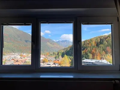 a window with a view of a town and mountains at Apartment MIMI in Kranjska Gora