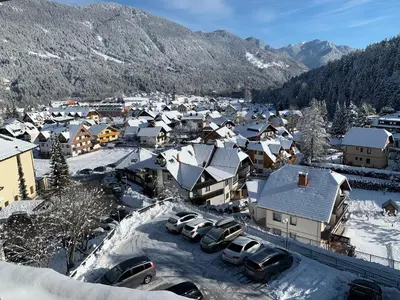 a small town covered in snow with cars parked at Apartment MIMI in Kranjska Gora