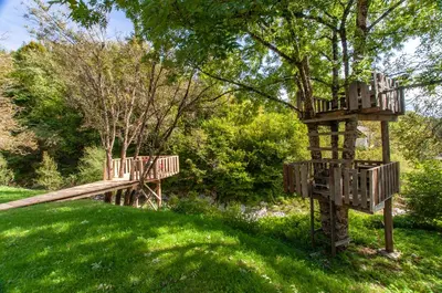 a wooden playground in a park with green grass at Bohinj Barn in Bohinj