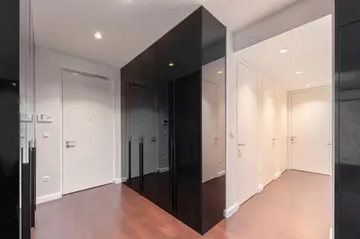 a hallway with white walls and a large black wall at Skyline Luxury Residence Jana in Ljubljana