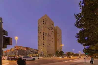 a tall building on a city street with cars at Skyline Luxury Residence Jana in Ljubljana