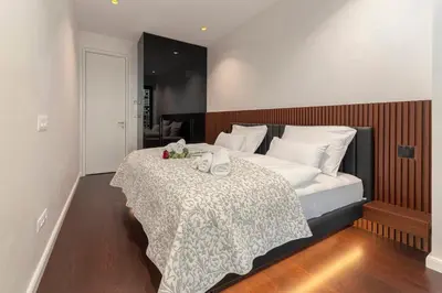 a bedroom with a bed with white sheets and towels at Skyline Luxury Residence Jana in Ljubljana