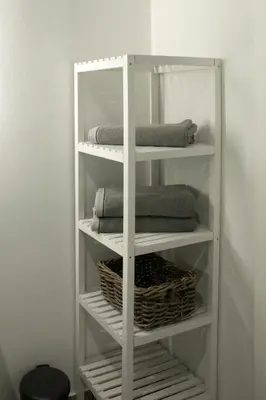 a white shelving unit with towels and a basket at Apartma Verdi Bc in Bovec