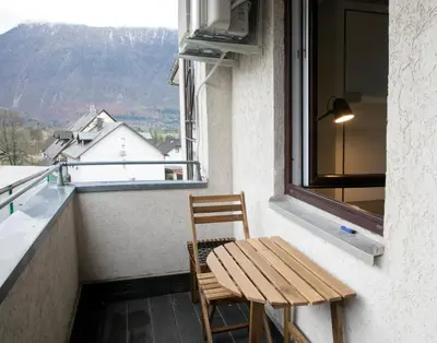 a chair and a table on a balcony with a window at Apartma Verdi Bc in Bovec