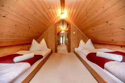 a room with two beds in a wooden cabin at Lake House with a View in Šmartno v Rožni Dolini