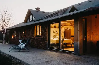 a house with glass doors and a chair on a patio at Lake House with a View in Šmartno v Rožni Dolini