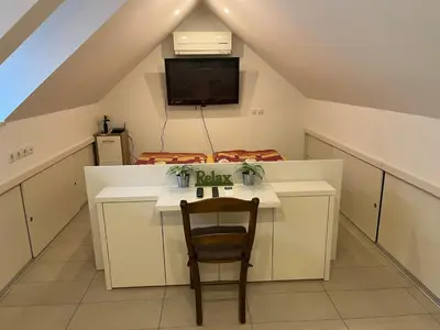 a table and a chair in a room with a tv at APARTMA AJDA in Kranj