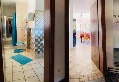 a bathroom with a toilet and a kitchen at Family House in Mozirje