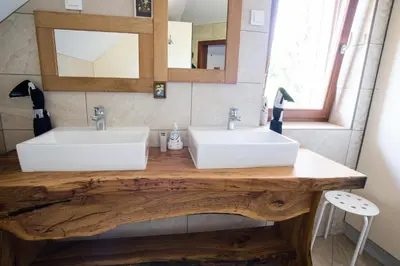 a bathroom with two white sinks on a wooden counter at Family House in Mozirje
