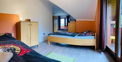 a bedroom with two beds in a room with orange walls at Family House in Mozirje