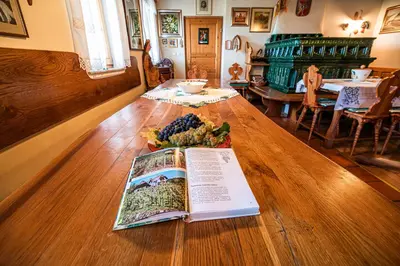 a book on a wooden table with a plate of grapes at Authentic Countryside Villa with Hot tub in Veliki Kamen