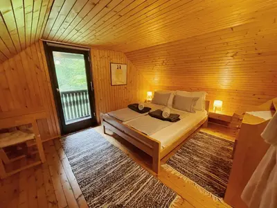a bedroom with a bed in a wooden room at Peaceful Nature Cabin Jolly in Mozirje