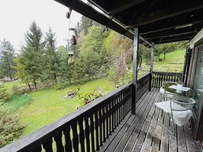 a deck with chairs and a view of a field at Peaceful Nature Cabin Jolly in Mozirje