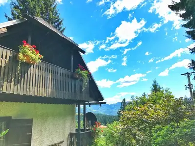 a house with flowers on the balcony of it at Peaceful Nature Cabin Jolly in Mozirje