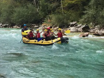 a group of people in a raft on a river at Alpeambient house Dovje in Mojstrana