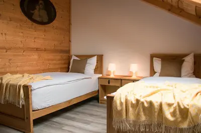two beds in a room with two lamps on tables at Ranch Kamovci21 in Dobrovnik
