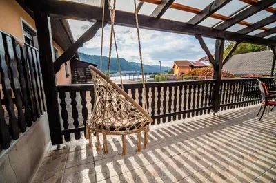 a swinging chair on a porch with a view at Rooms at Trimček in Sevnica