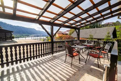 a patio with tables and chairs and a wooden pergola at Rooms at Trimček in Sevnica