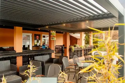 a restaurant with chairs and tables and a bar at Rooms at Trimček in Sevnica