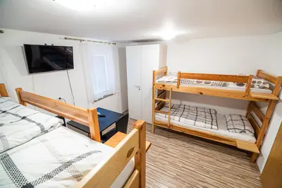 a room with two bunk beds and a tv at Rooms at Trimček in Sevnica
