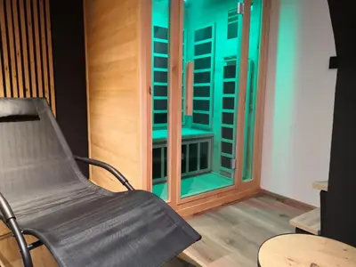a chair in front of a window with green lights at Apartments Alp in Bohinj