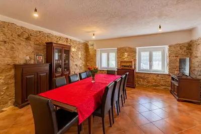 a dining room with a red table and chairs at Holiday country house Gora in Gozd