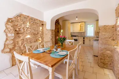 a kitchen and dining room with a wooden table and chairs at Holiday country house Gora in Gozd