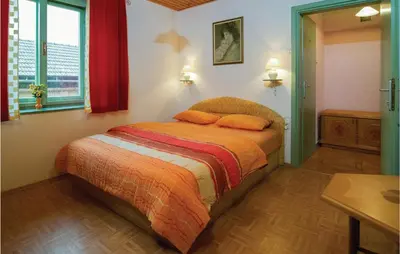 a bedroom with a bed with two orange pillows at 4 Bedroom Lovely Home In Kostel in Kupa