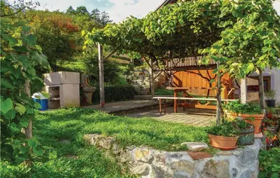 a garden with a wooden table and a bench at 4 Bedroom Lovely Home In Kostel in Kupa