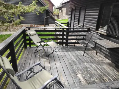two chairs and a table on a wooden deck at Tree Top Rogla Apartment in Zreče