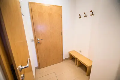 a hallway with a wooden door and a bench at Tree Top Rogla Apartment in Zreče