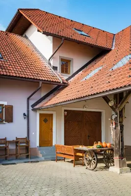a building with a bench and a table with fruit on it at APARTMENT ZYNGA - STUD FARM in Šentvid pri Stični