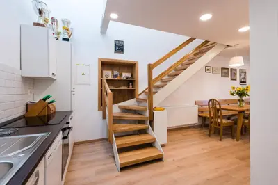 a kitchen and dining room with a spiral staircase at APARTMENT ZYNGA - STUD FARM in Šentvid pri Stični