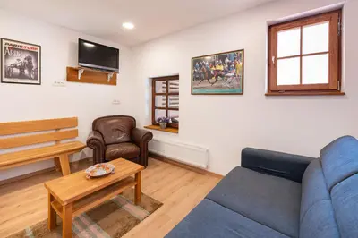 a living room with a blue couch and a tv at APARTMENT ZYNGA - STUD FARM in Šentvid pri Stični