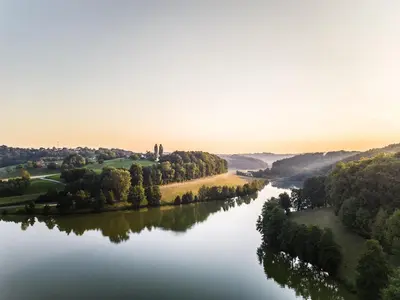 an aerial view of a river with trees and forests at Falkensteiner Premium Camping Lake Blagus in Sveti Jurij ob Ščavnici