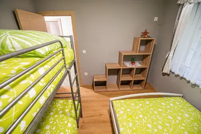 a bedroom with two bunk beds and a book shelf at Holiday Home with Hot tub and Sauna Sabina in Rovte