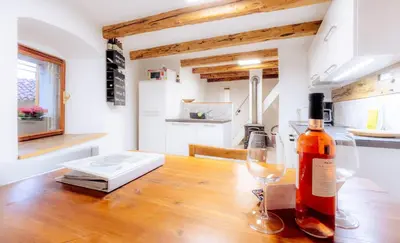 a bottle of wine sitting on a table with a wine glass at Apartment VILLA IRENA Great For a Family Holiday With Free Parking And EV Station in Ajdovščina