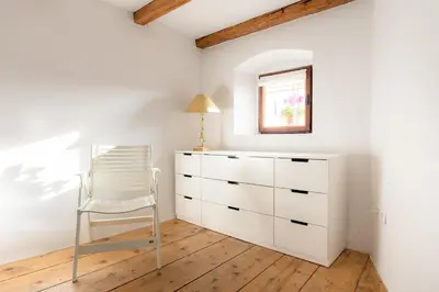 a white dresser and a chair in a room at Apartment VILLA IRENA Great For a Family Holiday With Free Parking And EV Station in Ajdovščina