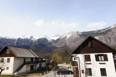 a couple of buildings with mountains in the background at Pierta Apartment in Bovec