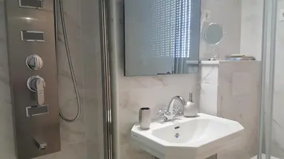 a bathroom with a sink and a shower with a mirror at E&E Apartments 4* Arena Stožice in Ljubljana