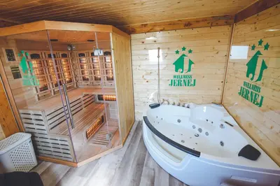 a sauna with a tub in a wooden cabin at Apartments Jernej with Onsite Wellness in Brežice