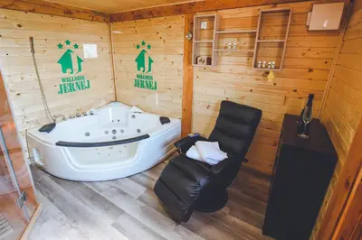 a sauna with a tub and a chair in it at Apartments Jernej with Onsite Wellness in Brežice