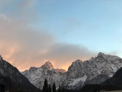 a view of a mountain range at sunset at APARTMA CARPE DIEM in Kranjska Gora
